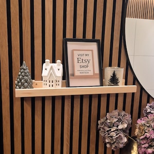 Könnte beinhalten: Set aus drei Keramikbechern mit gesprenkelter, matter Oberfläche. Die Becher sind in Creme-, Hellgrau- und Dunkelgrautönen gehalten. Jede Tasse hat ein schlichtes, minimalistisches Design.