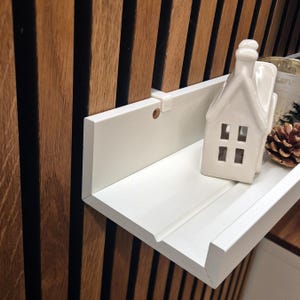 Könnte beinhalten: Ein Set aus drei Keramikbechern mit gesprenkelter, matter Oberfläche. Die Becher sind in Creme-, Hellgrau- und Dunkelgrautönen gehalten. Jeder Becher hat ein schlichtes, minimalistisches Design und einen abgerundeten Griff.