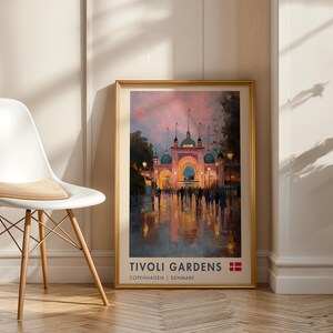 May include: A framed art print featuring an impressionistic painting of the Tivoli Gardens entrance in Copenhagen, Denmark, at dusk. The print includes the text TIVOLI GARDENS, COPENHAGEN | DENMARK, and a small Danish flag icon at the bottom.