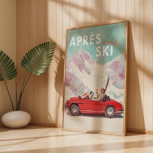 May include: A framed vintage poster with the words "APRÈS SKI". The poster shows a red convertible car with a person inside, set against a snowy mountain backdrop. The poster is in a wooden frame and leans against a wall. The poster is in a wooden frame.