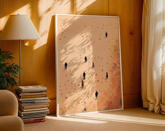May include: A framed art print featuring an abstract landscape with small figures walking across a textured, tan surface. The artwork has a white border and is displayed in a room with warm lighting and a stack of books.