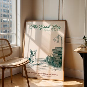 May include: A framed print with the text "The Good Boy Book Club" in green script. The print features a corgi dog, a stack of books, and a lamp. The bottom of the print reads "Quiet mornings, good stories, better company."