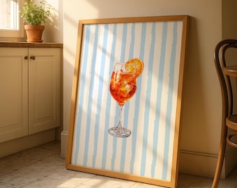May include: A framed watercolor print of a cocktail with an orange slice garnish. The drink is in a stemmed glass with ice cubes. The background has blue and white vertical stripes. The frame is made of wood.