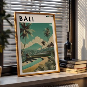 May include: A framed art print featuring a Bali landscape with palm trees, rice terraces, and a mountain. The word "BALI" is at the top. A bottle of wine and books are on a windowsill.