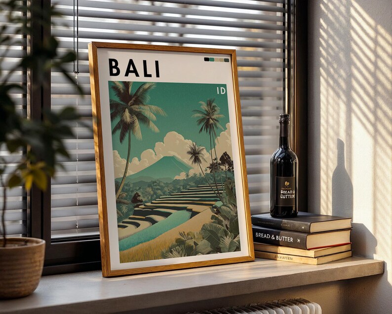May include: A framed art print featuring a Bali landscape with palm trees, rice terraces, and a mountain. The word "BALI" is at the top. A bottle of wine and books are on a windowsill.