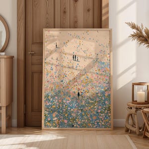 May include: A framed art print featuring an abstract landscape with colorful brushstrokes in shades of pink, blue, and yellow. Small figures are scattered throughout the scene, suggesting people on a beach or in a field. The artwork is displayed in a light wood frame.