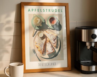 May include: A framed print with the words "APFELSTRUDEL" and "DEUTSCHLAND" features a detailed illustration of apple strudel, coffee, and cream. A white mug and a coffee maker are on the counter.