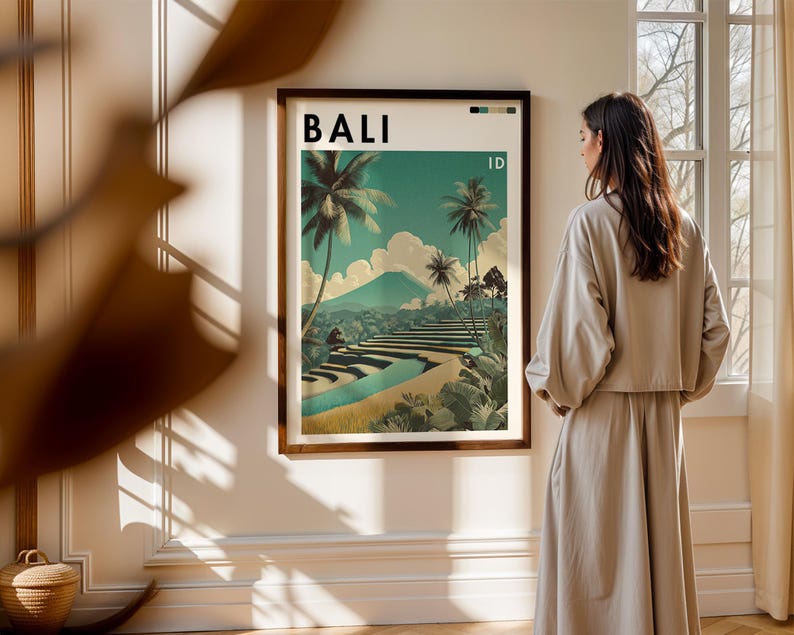 May include: A framed art print featuring a vintage travel poster design for Bali, Indonesia. The poster displays a scenic landscape with palm trees, terraced fields, and a mountain under a teal sky. The word "BALI" is at the top.
