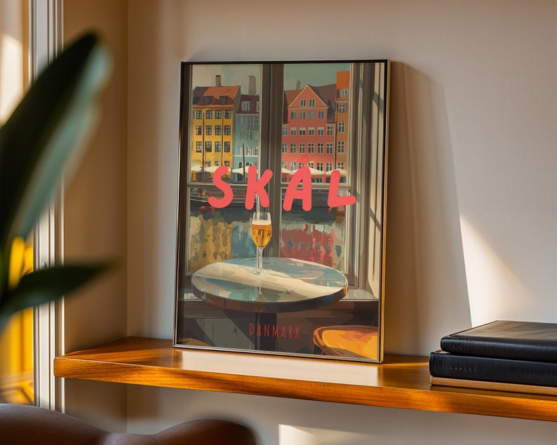 May include: Framed art print featuring a window view of colorful buildings and a glass of beer on a table. The word "SKAL" is written in pink letters across the top. The word "DANMARK" is written at the bottom.