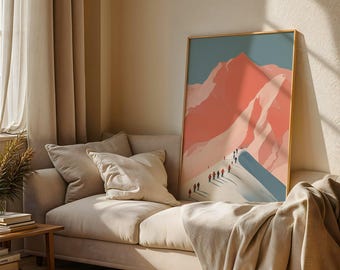 May include: A framed art print featuring a mountain scene with a pink and blue color palette. The artwork depicts a mountain range with people hiking along a snowy ridge. The print is displayed on a beige sofa with pillows.