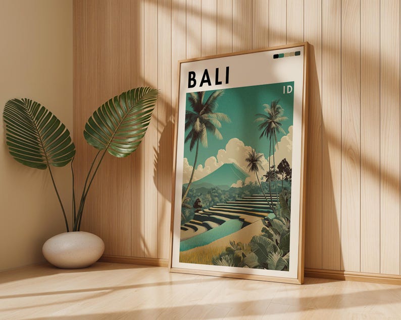May include: A framed art print featuring a scenic illustration of Bali, Indonesia. The artwork showcases palm trees, terraced rice fields, and a mountain under a teal sky. The word "BALI" is printed at the top, with "ID" below it.