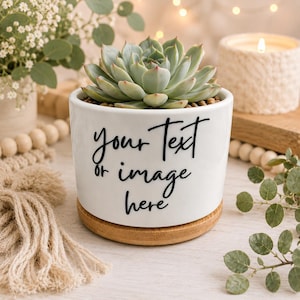 May include: A white ceramic cylindrical planter with a bamboo saucer base, containing a green succulent plant. The front of the planter features the black printed text: your Text or image here, written in a cursive, handwritten-style font.