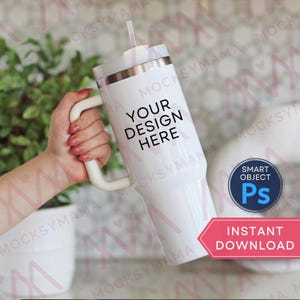 May include: A white tumbler with a handle and a straw, featuring the text "YOUR DESIGN HERE." The tumbler has a silver rim and a white handle. A pink and white banner reads "INSTANT DOWNLOAD."