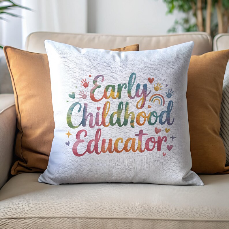May include: White square cushion featuring the text "Early Childhood Educator" in rainbow colours. The design includes handprints, hearts, a rainbow, and stars. The cushion is on a beige sofa with orange cushions.
