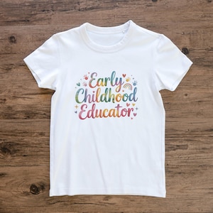 May include: White t-shirt featuring the words "Early Childhood Educator" in a vibrant, multi-coloured design. The design includes handprints, hearts, and a rainbow. The shirt is made of a soft material.