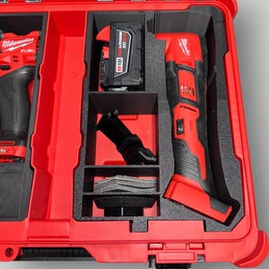 May include: A red and black power tool kit with multiple compartments. The kit includes a red and black oscillating multi-tool, a battery, and various accessories. The tools are neatly organized within a red carrying case.