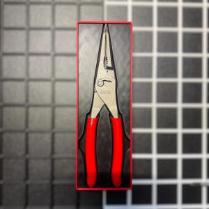May include: Long nose pliers with red handles, presented in a red-lined black case. The pliers are silver with the word "ICON" printed on the side. The tool is designed for precision work and is suitable for various tasks.