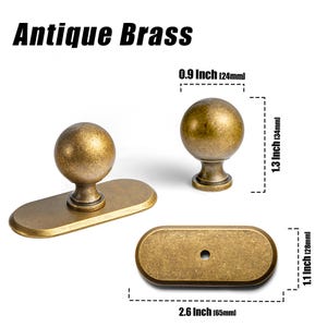 May include: Antique brass cabinet hardware set. Includes a round knob, a knob with an oval backplate, and an oval backplate. The round knob is 0.9 inches (24mm) in diameter and 1.3 inches (34mm) tall. The oval backplate is 2.6 inches (65mm) long and 1.1 inches (28mm) wide.