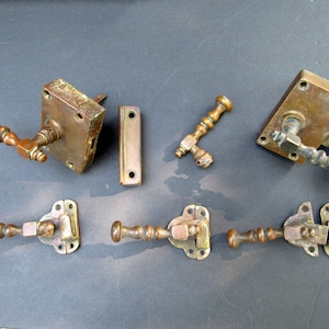 May include: Antique brass door hardware set, including handles, latches, and plates. The handles have a detailed, twisted design. The set is aged with a patina, suggesting vintage or reclaimed pieces. Ideal for restoration projects.