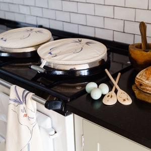 Penguin Aga chef hob pad cover with Rockhopper penguin design. With hanging loop and made in the UK.