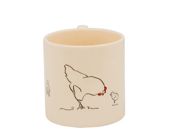 May include: A white ceramic mug with a black and red illustration of a hen and chicks. The hen is looking down at a chick.