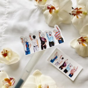 May include: A sticker showing a watercolour illustration of five figures with raised arms. The figures are dressed in diverse outfits, including a football jersey and a striped top. The sticker is on a white surface with orchids.