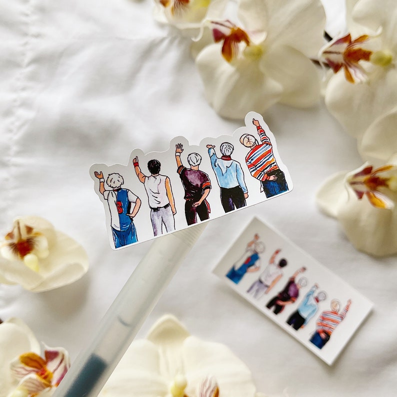 May include: A sticker showing a watercolour illustration of five figures with raised arms. The figures are dressed in diverse outfits, including a football jersey and a striped top. The sticker is on a white surface with orchids.