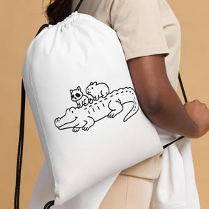 Bonita bolsa con cordón de animales: mapache bebé y capibara montando caimán. Divertida bolsa de gimnasio con dibujos animados. Un regalo ideal para los amantes de los animales.