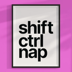Puede incluir: Una impresión enmarcada en blanco y negro con el texto "shift ctrl nap" en letras negras y en negrita.