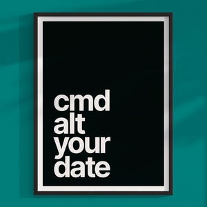 Puede incluir: Una impresión artística en blanco y negro enmarcada. La impresión presenta las palabras "cmd alt your date" en una fuente en negrita y sin serifa. La obra de arte está sobre un fondo negro y enmarcada con un marco negro fino.