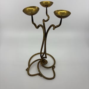 May include: A white ceramic mug with a black handle and the text "But First, Coffee" in a black, handwritten-style font. The mug is on a white surface.