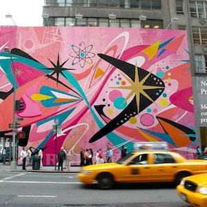 May include: A large, vibrant mural on a city building facade featuring abstract mid-century modern shapes, starbursts, and an atomic symbol in shades of pink, teal, black, and yellow. Text on the right reads: Need a Larger Print? Message us for custom sizes and prices!