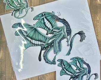 May include: Two green and blue butterfly-like dragons with white markings are intertwined. The dragons are drawn in a realistic style with intricate details. The image is printed on white paper.