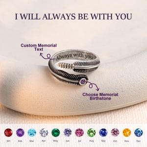 Op de afbeelding: Een zilverkleurige metalen ring in de vorm van een veer met een paarse edelsteen aan één uiteinde. De binnenkant van de ring is gegraveerd met de tekst Always with you. De afbeelding bevat de tekst I WILL ALWAYS BE WITH YOU, Custom Memorial Text en Choose Memorial Birthstone, samen met een overzicht van twaalf gekleurde geboortestenen gelabeld per maand.