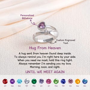 May include: A silver ring with a heart-shaped purple gemstone and hugging arms design. The ring has the text "Kelly" engraved on it and the words "Hug From Heaven" are written below. The ring is a personalized bithstone.