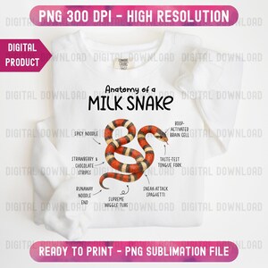 Könnte beinhalten: Weißes Sweatshirt mit einer detaillierten Illustration einer Milchschlange und anatomischen Beschriftungen. Das Design enthält den Text "Anatomy of a Milk Snake" und humorvolle Beschriftungen wie "Spicy Noodle" und "Sneak-Attack Spaghetti".