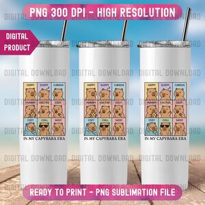 May include: Three white 20 oz. stainless steel tumblers with black straws. Each tumbler features a colorful graphic of capybaras with different emotions, including "Happy," "Sleepy," and "Curious." The text "IN MY CAPYBARA ERA" is below the graphic.