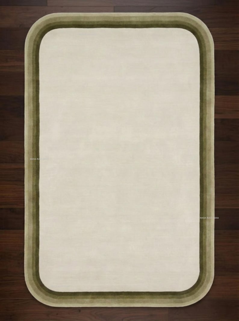 K&ouml;nnte beinhalten: Rechteckiger Teppich in Creme mit einem Rand in Olivgr&uuml;n- und Braunt&ouml;nen. Der Teppich hat abgerundete Ecken und eine weiche Textur, geeignet f&uuml;r Wohn- oder Schlafzimmer. Die Ma&szlig;e des Teppichs sind in Zentimetern.