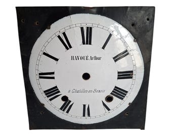 May include: A square black metal clock face featuring a circular white enamel dial with black Roman numerals. The centre displays the text HAVOUÉ Arthur and à Chatillon-en-Bazois. The dial has a central hole and two smaller circular openings.