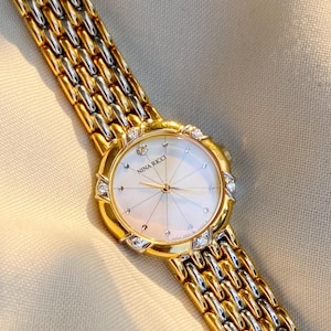 Reloj vintage Nina Ricci, esfera de nácar, bicolor con detalles de diamantes; en perfecto estado.