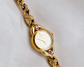 Reloj Seiko vintage raro con esfera redonda de rubí y detalles dorados para mujer.