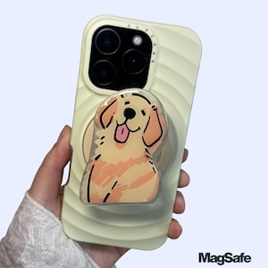 Peut inclure: Coque de téléphone jaune clair avec un dessin de chien de dessin animé et un support et une poignée de téléphone MagSafe. La coque du téléphone a une texture nervurée. Le chien est brun clair avec des contours noirs et une langue rose.