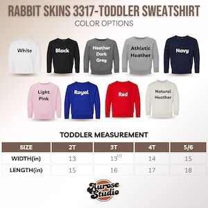 May include: A product image showcasing a Rabbit Skins 3317 toddler sweatshirt. Color options include white, black, heather grey, athletic heather, navy, light pink, royal blue, red, and natural heather. Measurement details are provided in inches for sizes 2T to 5/6.