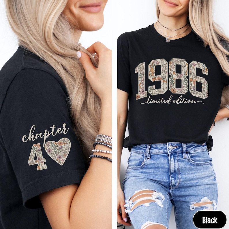 May include: Black t-shirt with the year "1986" in a floral design and the words "limited edition". The left sleeve has "chapter 40" with a floral heart. The shirt is worn with blue jeans.