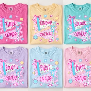May include: Six short-sleeve t-shirts in pink, yellow, teal, lavender, light blue, and light pink. Each shirt features a graphic of two pennants with the text Third Grade, Kinder Garten, Second Grade, Fourth Grade, First Grade, and Fifth Grade.