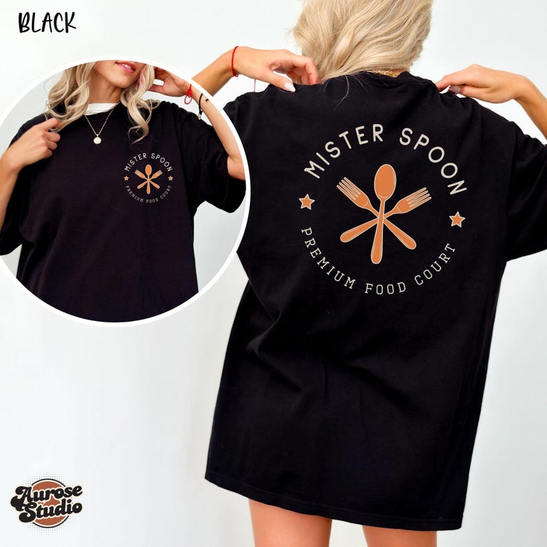 May include: Black t-shirt with the text "MISTER SPOON PREMIUM FOOD COURT" in a circular design on the back and a smaller version on the front. The design features a spoon and two crossed forks. The shirt is a comfortable, oversized fit.