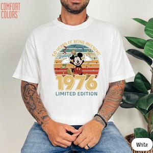 Puede incluir: Camiseta blanca con un dise&ntilde;o vintage de Mickey Mouse celebrando su 50 aniversario. El dise&ntilde;o incluye el texto "50 Years of Being Awesome", "Vintage" y "1976 Limited Edition".