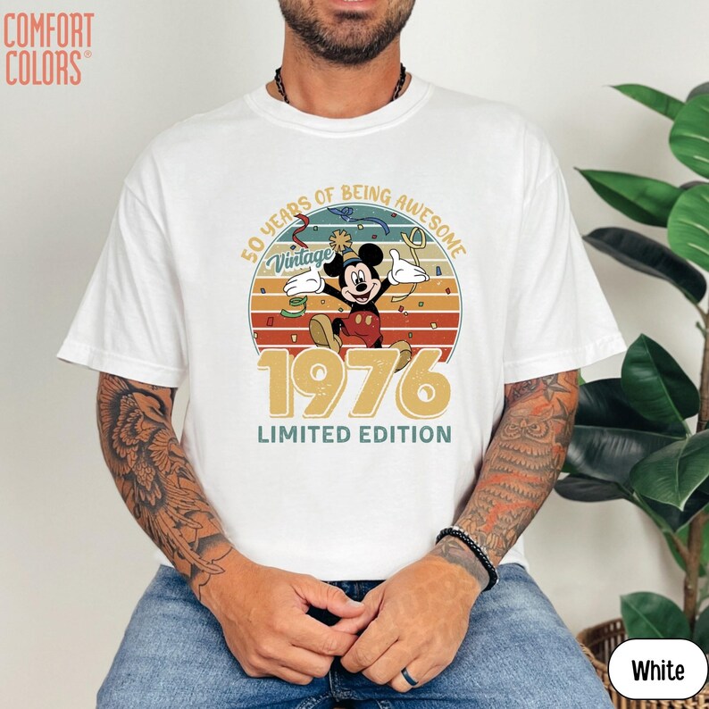 Puede incluir: Camiseta blanca con un dise&ntilde;o vintage de Mickey Mouse celebrando su 50 aniversario. El dise&ntilde;o incluye el texto "50 Years of Being Awesome", "Vintage" y "1976 Limited Edition".
