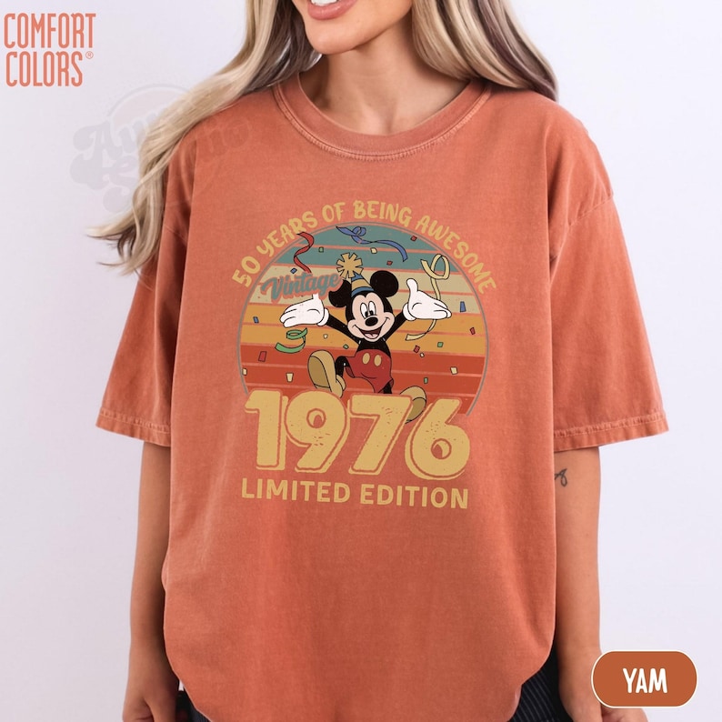 Puede incluir: Camiseta naranja Comfort Colors con un dise&ntilde;o de Mickey Mouse que celebra un 50 cumplea&ntilde;os. El dise&ntilde;o incluye el texto "50 Years of Being Awesome" y "1976 Limited Edition."