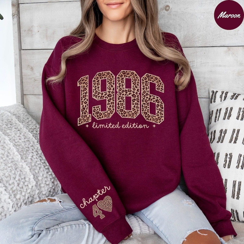 Op de afbeelding: Bordeaux sweatshirt met het jaar "1986" in luipaardprint, de woorden "limited edition" eronder en "chapter 40" op de mouw. De sweatshirt heeft een ronde hals.